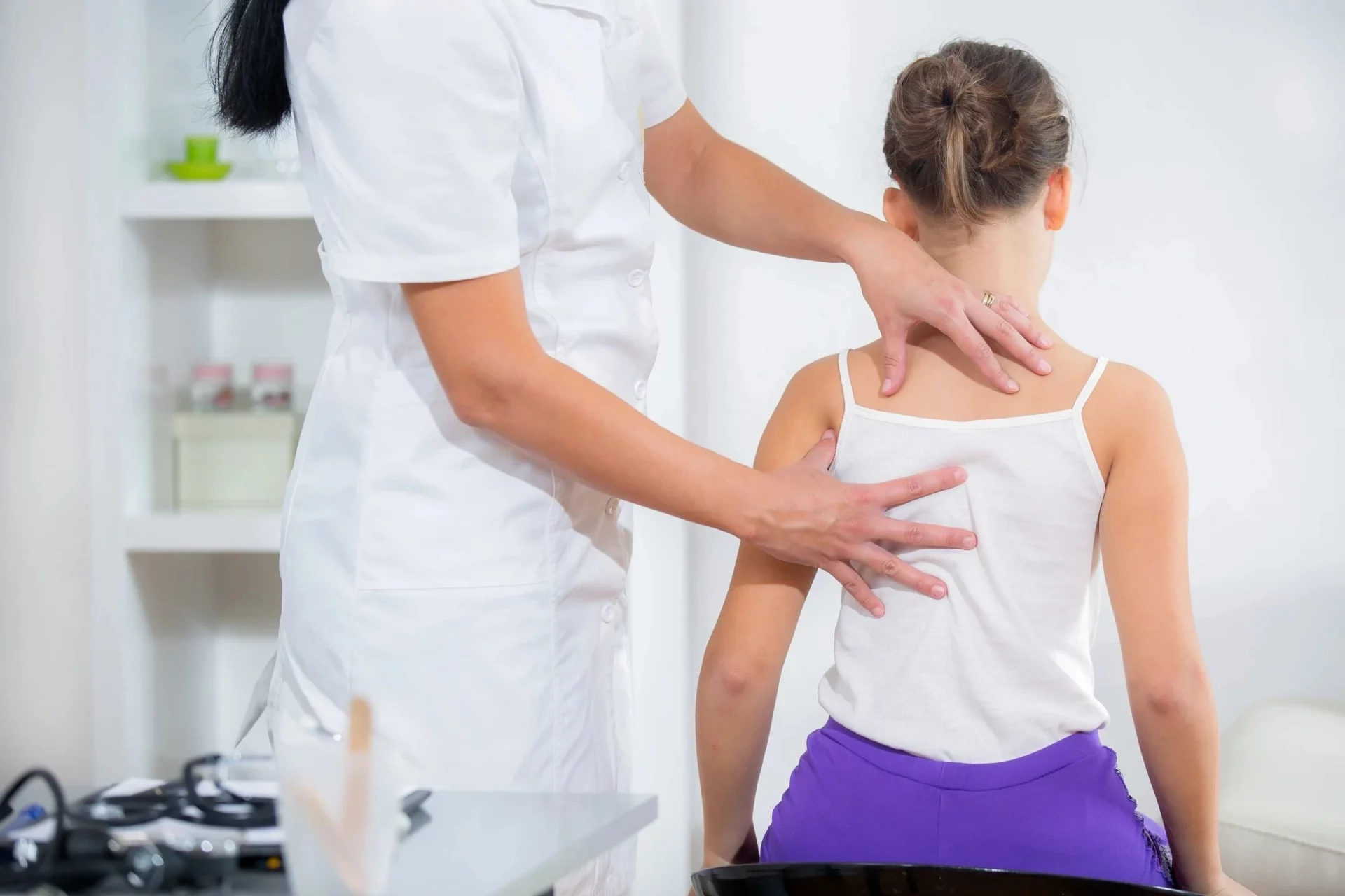 A person is getting their neck examined by an osteopath.